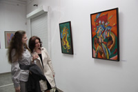 Посетители выставки «На берегах иных миров» перед картинами Татьяны Туркулец