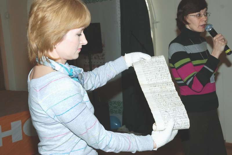 Сотрудник музея О.В. Тарасова  демонстрирует рукописные свитки XVII в.